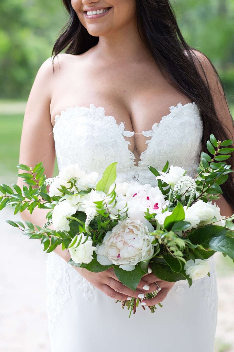 bride holds her bouquet during her bridal portraits at Balmorhea Wedding Venue in Houston by Swish and Click Photography