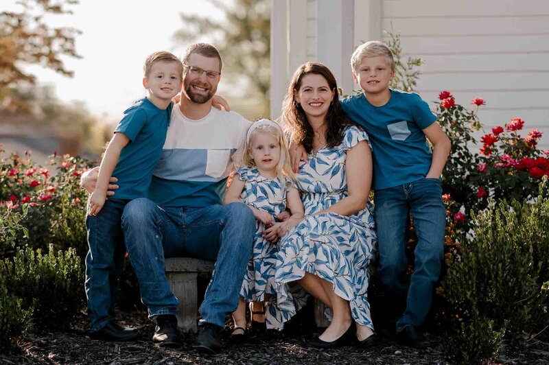 Family gathers with grandparents and grandchildren to take a photo.