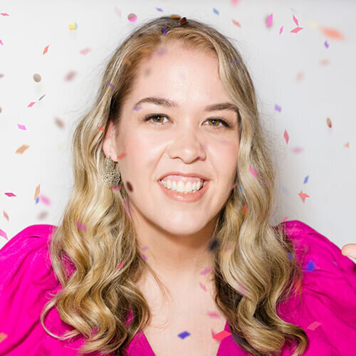 Headshot of Angela Henderson smiling with confetti falling around her