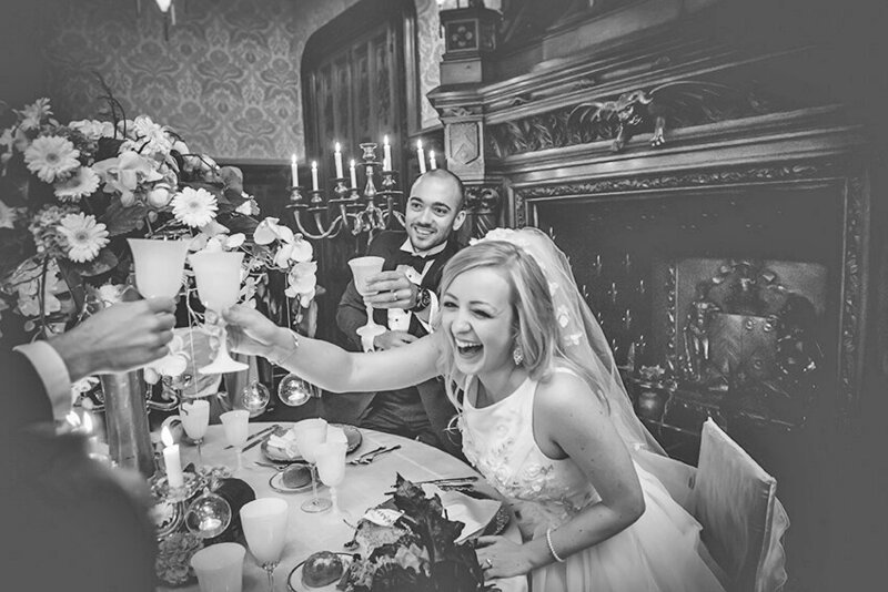 Bride and groom laughing and toasting during their wedding dinner at Château Challain, captured in natural, joyful, romantic wedding photography.