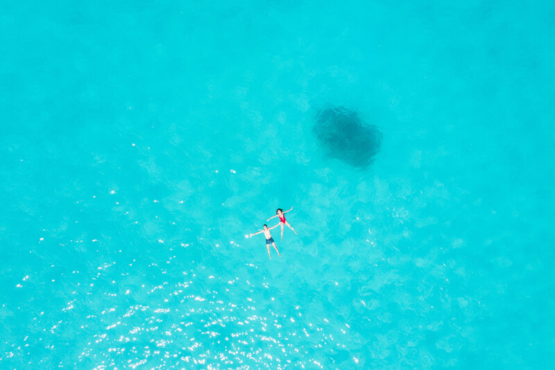 Aeriel Drone view couple in the Bora Bora blue lagoon