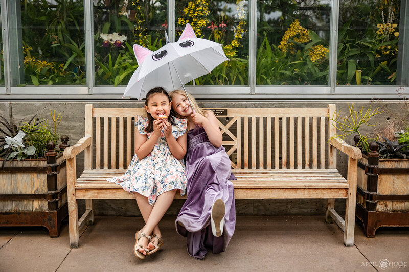 Kids sit on a bench inside the Orangery at Denver Botanic  Gardens