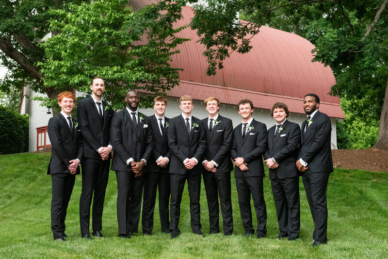 Spring wedding at WinMock at Kinderton, designed by Charming Carolina — group photo of groomsmen in black suits standing together outside the venue.