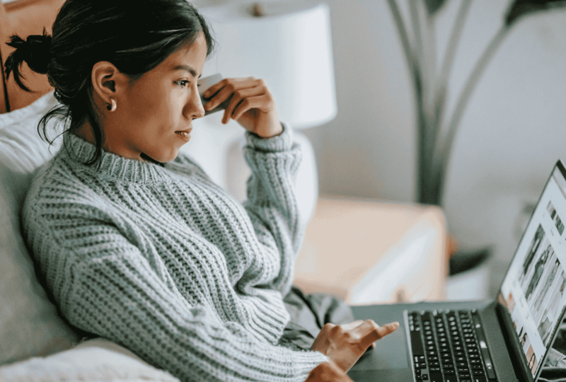 Woman sitting on couch looking contemplative while reviewing PANCE study materials