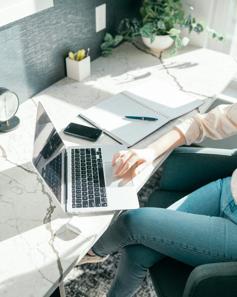woman at table with coffee and a laptop 
