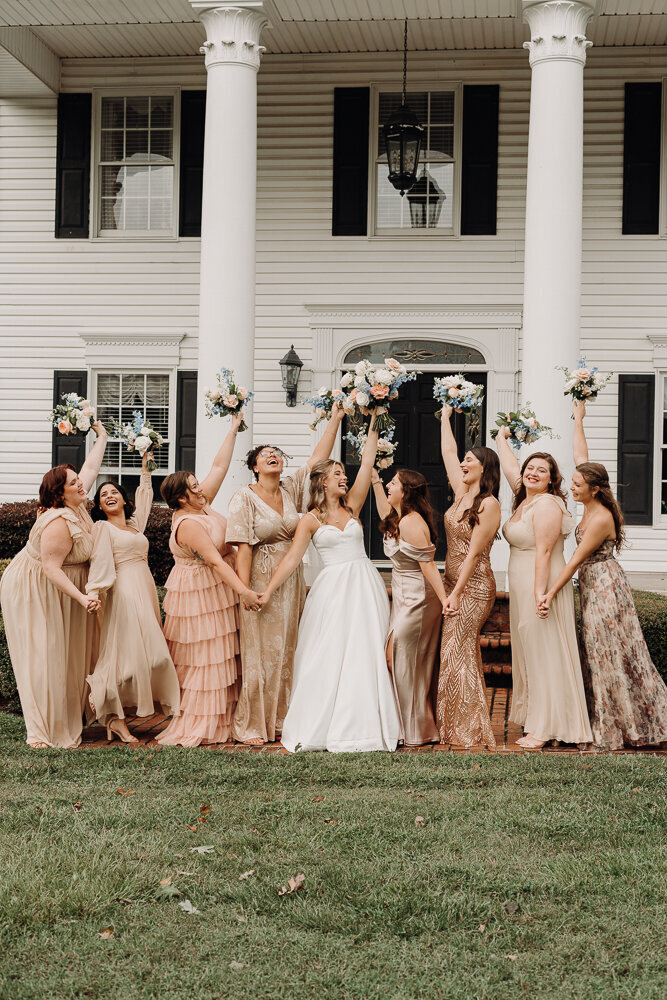 bridal party throwing hands in the air with flowers