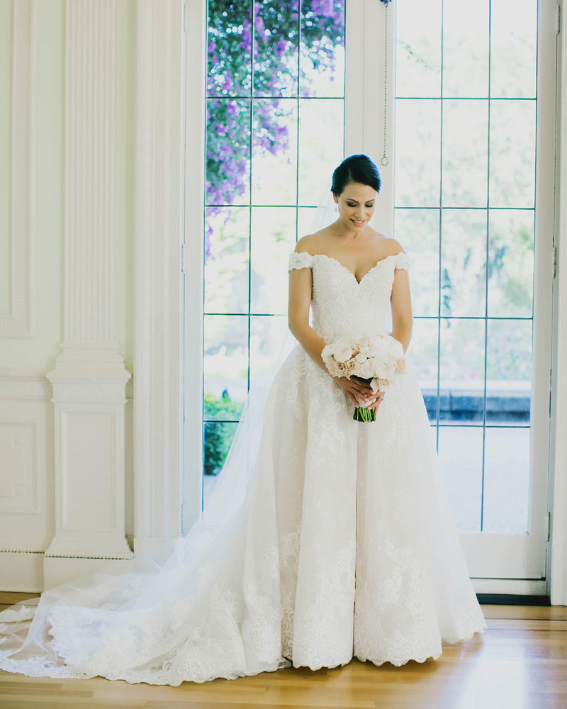 Bride holding bouquet looking down at her bouquet