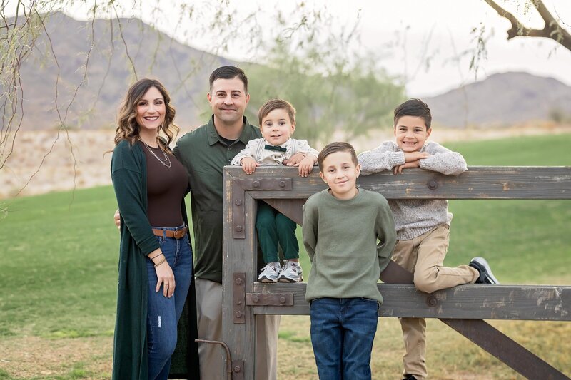 wife and husband and three sons looking at camera