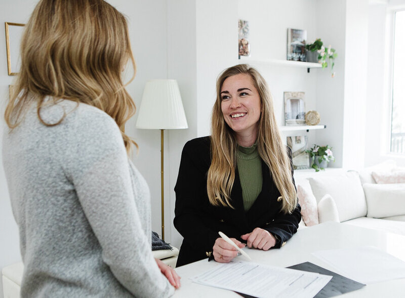 Radiating warmth and professionalism, Realtor Tamara Rzan smiles brightly while helping her client discuss their dream home wants and needs