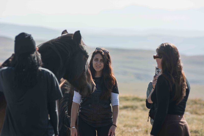 Group of women standing in circle at an equine-assisted learning session