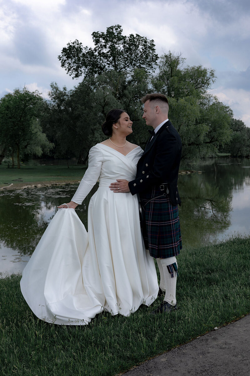 Playful wedding portraits next to a serene Ontario lake