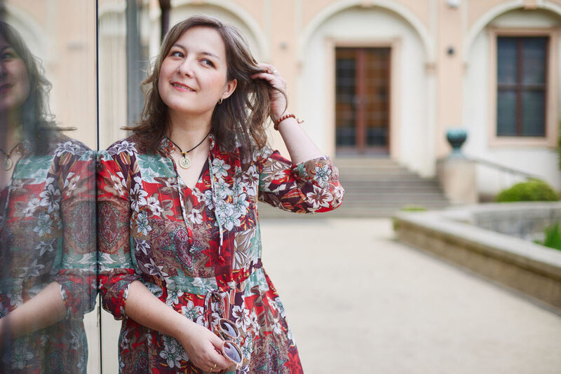 Portrait of Zuzana leaning towards a glass door, playing with her hair