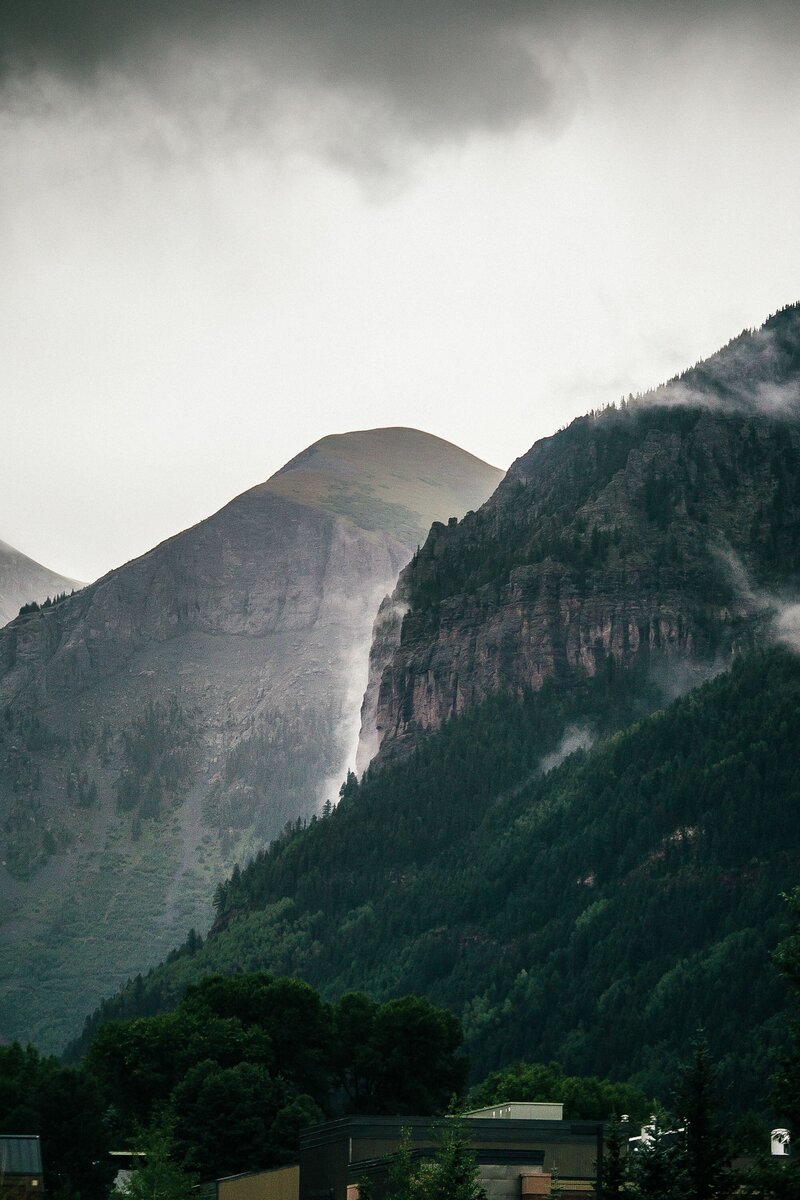 foggy cliffside mountains with small clouds