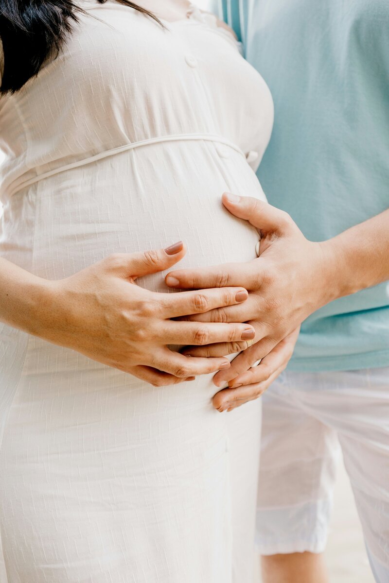 Man and woman's hands on woman's pregnant belly