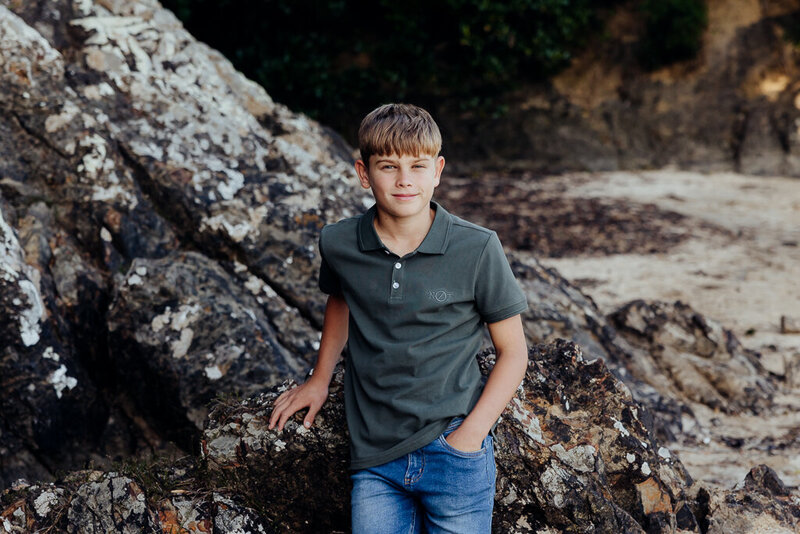 Teenage boy sitting on a rock during family potrait session with Whangarei photographer Tracey Morris