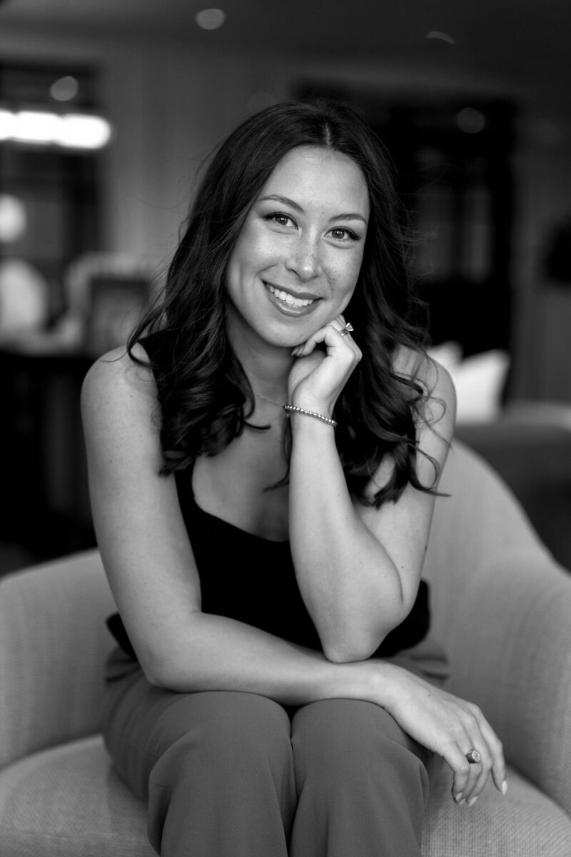 Claire Glynn poses gracefully in a black-and-white portrait beside a beautifully set table. Photo by Logan Alexander