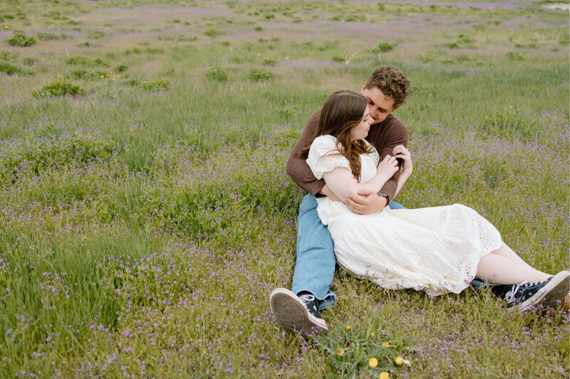 A man holding his girlfriend in a lavender flower field.