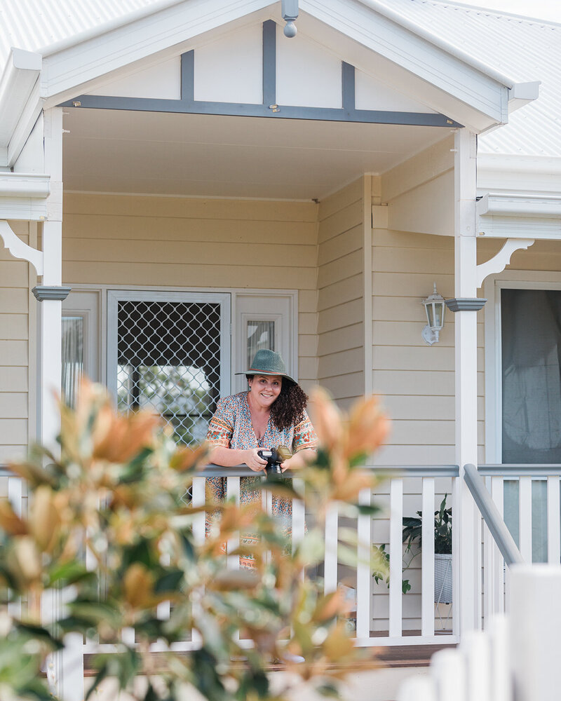 Portrait of professional photographer standing on porch of home.