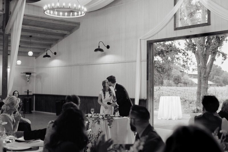 Newlyweds sharing a romantic black-and-white kiss at their reception, documented by T M Pic Love (TM Photography), a Sacramento professional photographer specializing in in the moment wedding celebrations.