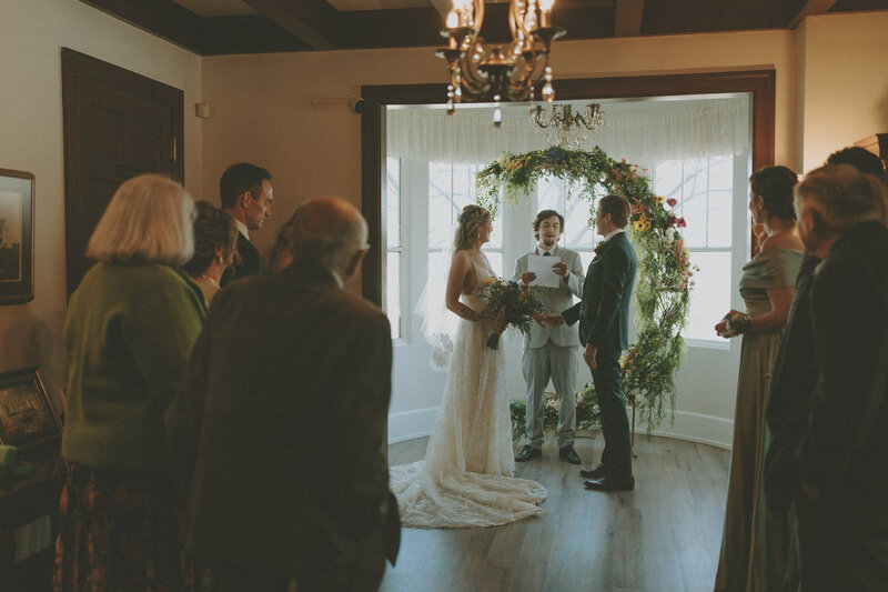 bride and groom plus guests standing at ceremony