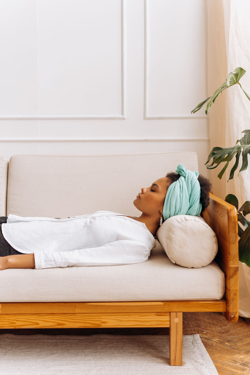 Woman lying down on sofa in calm room