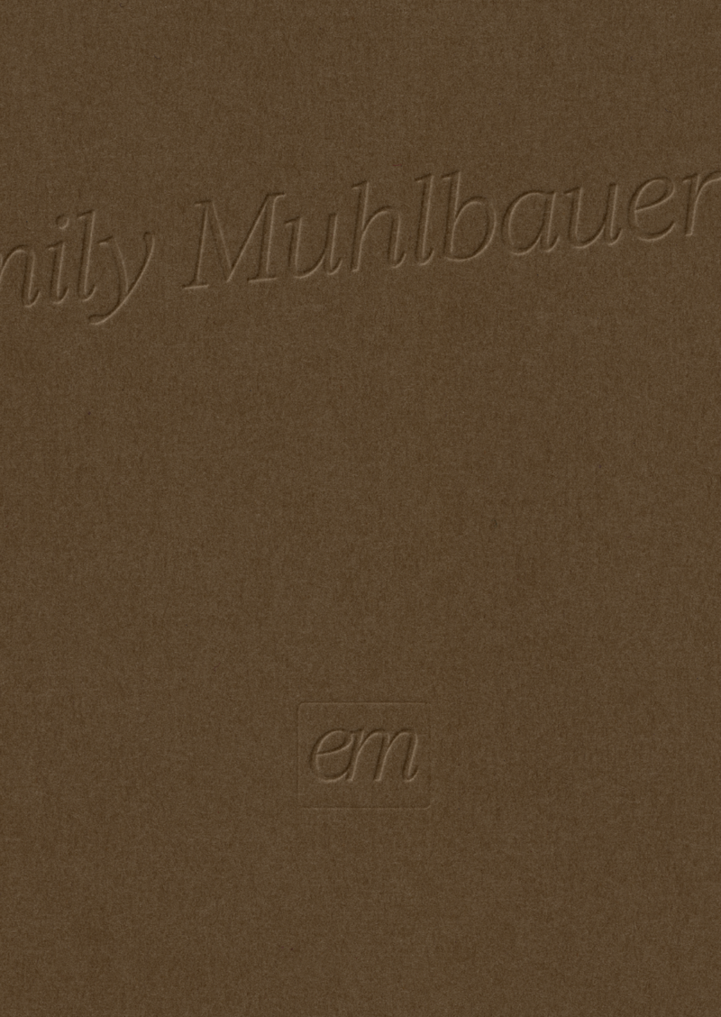 A close-up of Emily’s refined brand mark printed on textured paper.