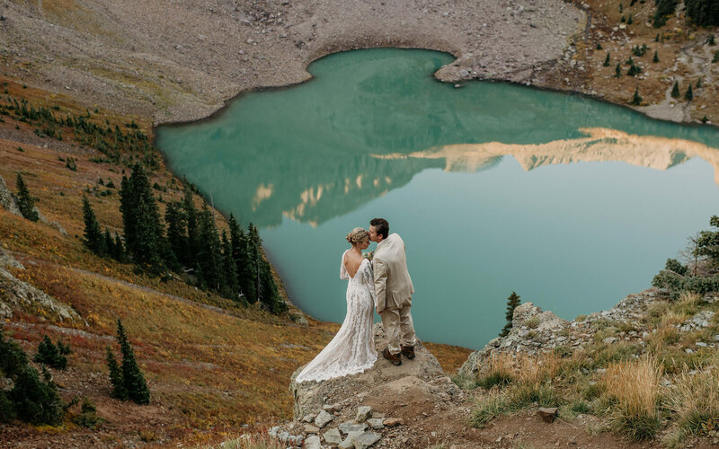 Couple getting married above a turquoise lake in Colorado.