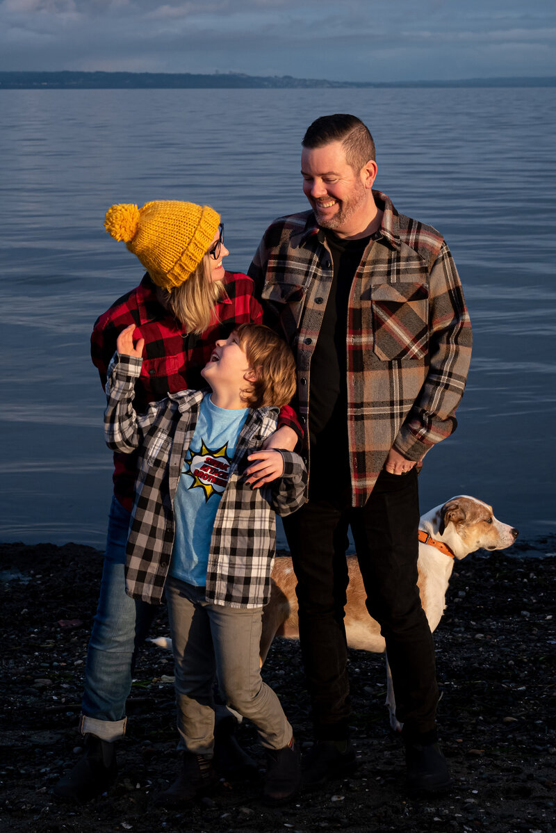 Family of three with their dog on Centennial beach at sunset in the fall