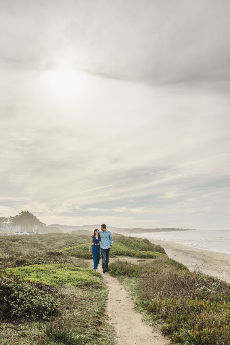 A couple walking along a small path along a cliffside walk