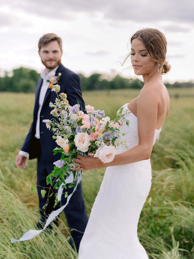 candid moment of bride and groom in field