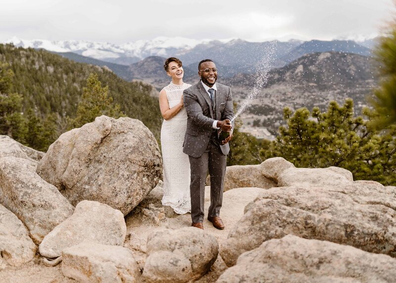 Couple pops champagne in celebration of their Colorado elopement in Rocky Mountain National Park with elopement photographer and videography Alpine Vows