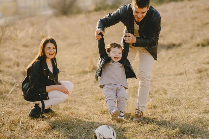 dad playing with son swinging him in the air