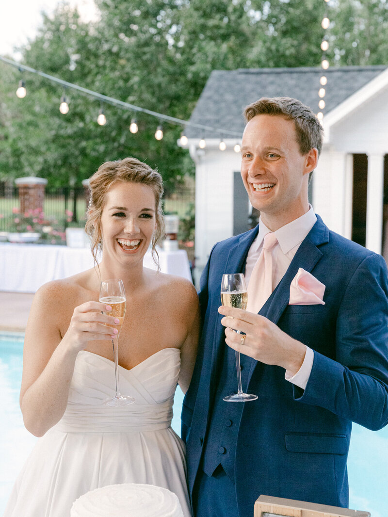 Virginia Wedding Photography of a  bride  and groom holding champagne glasses and laughing