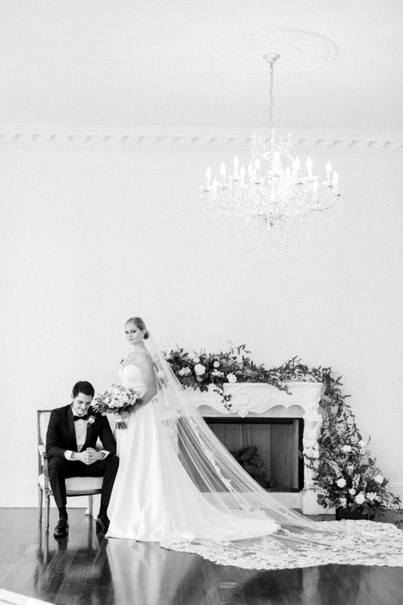 Bride standing by groom infront of floral fireplace