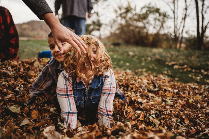 hand wiping leaves from child's hair