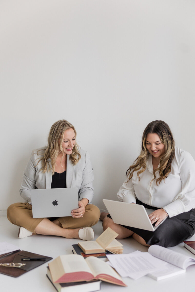 Lawyers, Paige Griffith & Alisha Suazo, work on laptops