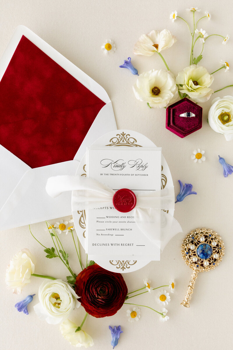 Oval letterpress wedding invitation with red velvet envelope liner