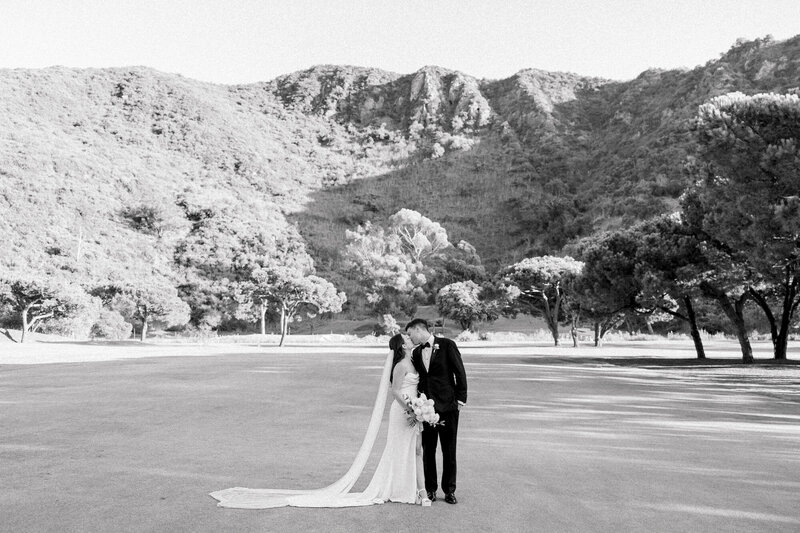 couple kissing in front of a mountain