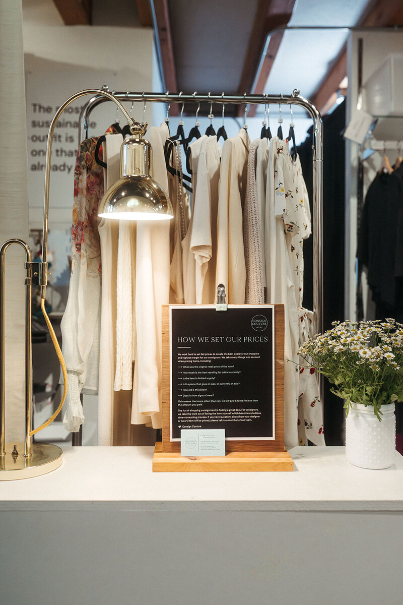 A person shopping in a store and holding up a shirt on a hanger 