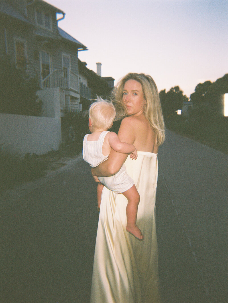 Film photo of mom in yellow dress holding her baby