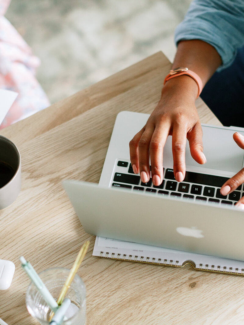 An image of the hands of a user using a laptop