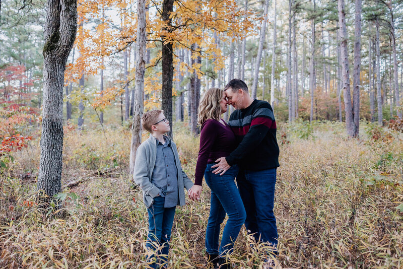 Fall family portrait session taken in the woods of a family of three. 