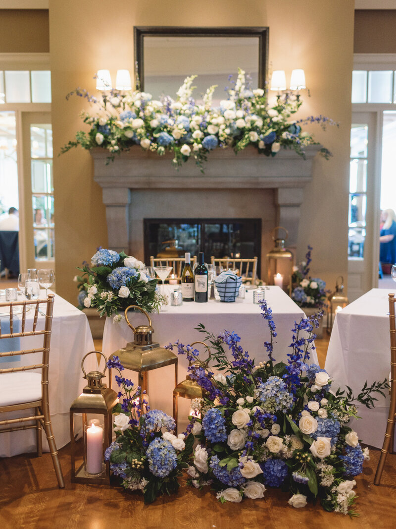 modern sweetheart table at wedding reception with large florals and lanterns
