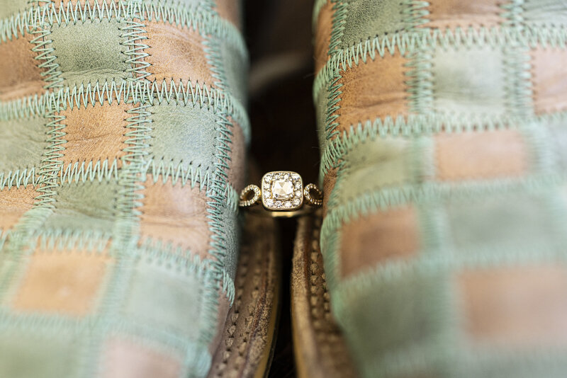 Detail shot of the wedding ring and cowboy boots of the bride at intimate backyard wedding in Northern California. 