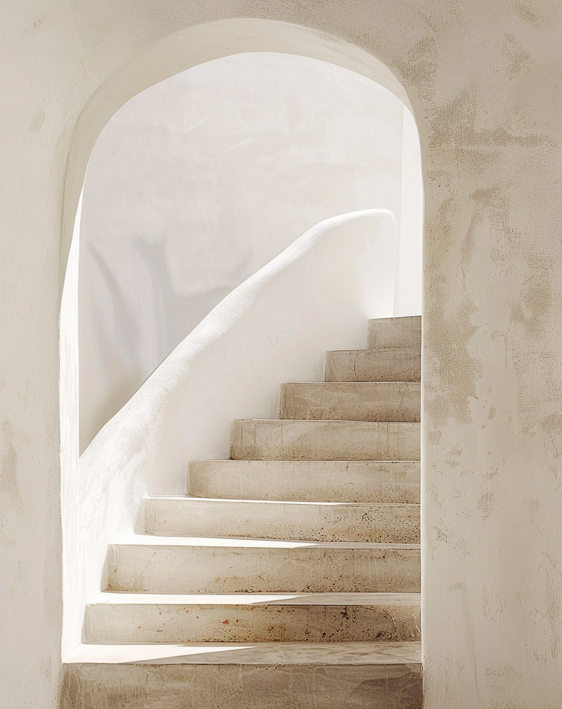 arched doorway into stairwell in the sunshine all creamy whites plastered walls
