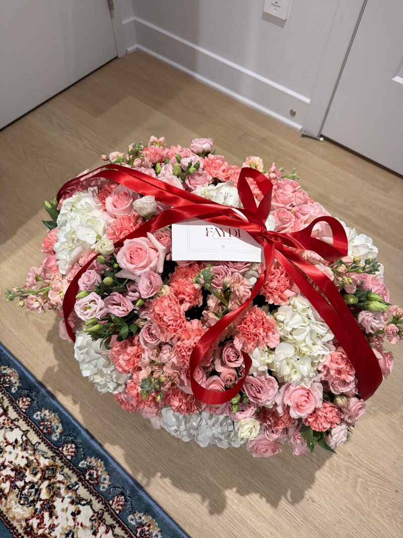 Romantic bouquet of flowers with pink roses, hydrangea, and lisianthus, arranged in a luxury style with a red ribbon for everyday gifting.