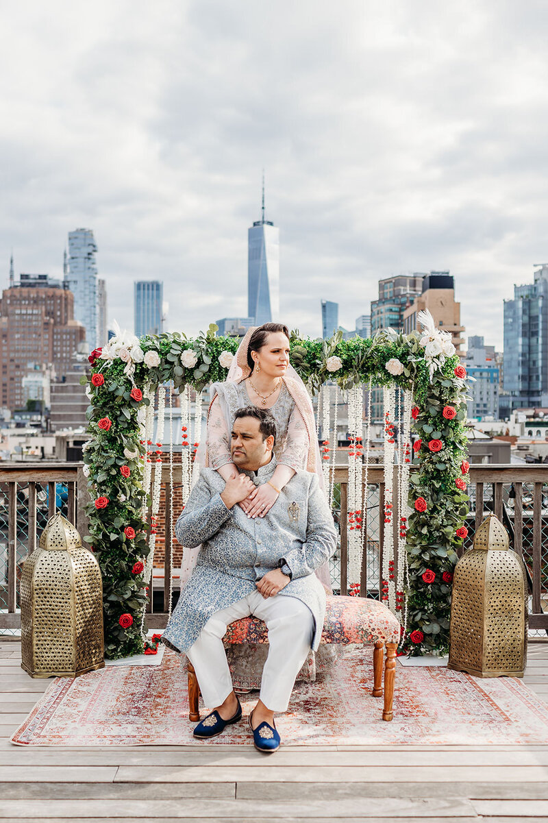Bride embraces her groom with NYC skyline in the background