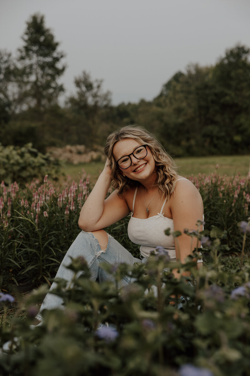 girl poses in field for senior photos