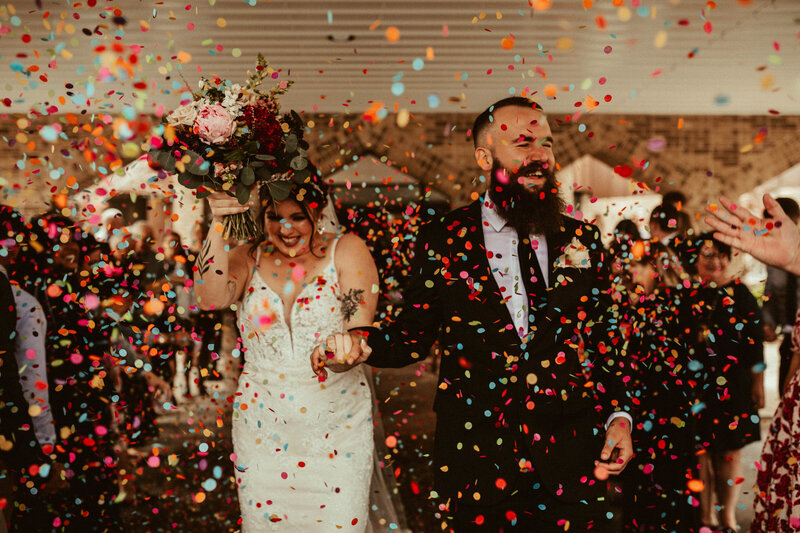 couple running out of cincinnati wedding ceremony with confetti thrown on them