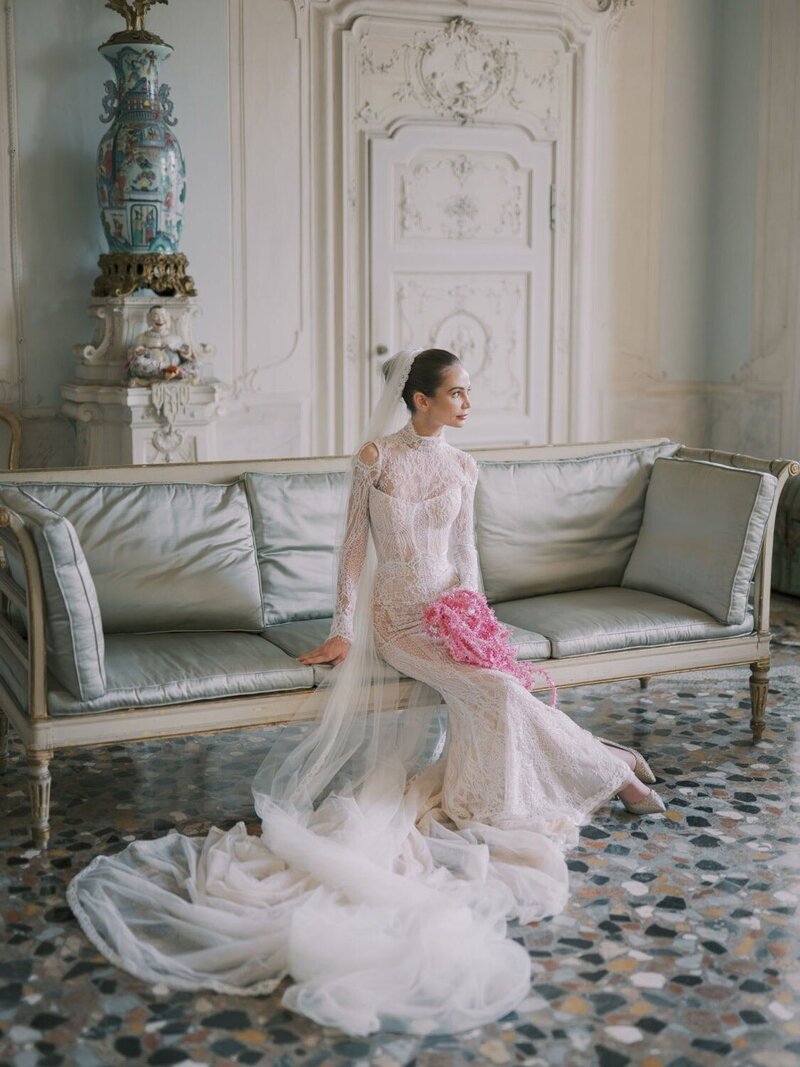  Bridal portrait during a villa Sola Cabiati wedding, bride sitting on an antique sofa in the Stucco Room, photographed by luxury destination wedding photographer Andreas K. Georgiou  